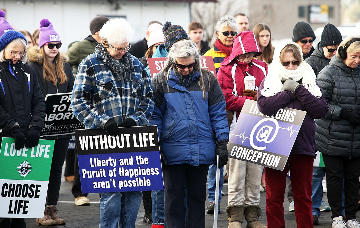 People bow their heads in prayer before marching on Saturday in the Right to Life rally in Coeur d'Alene.