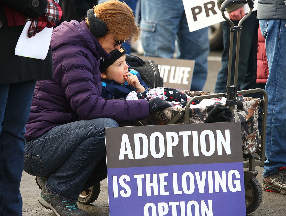 Mayanna Hawk and son David Hawk pause during a prayer at the Right to Life rally in Coeur d'Alene on Saturday.