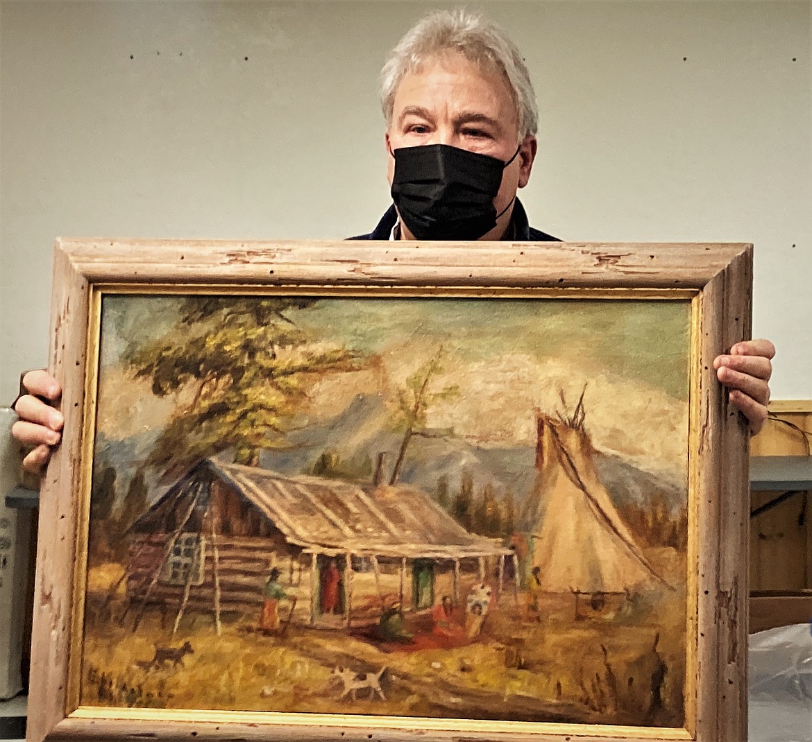 Joe Abbrescia displays a 1956 painting of an original trapper cabin that he was able to clean and restore after it was damaged in the People's Center fire of 2000. (Carolyn Hidy/Lake County Leader)