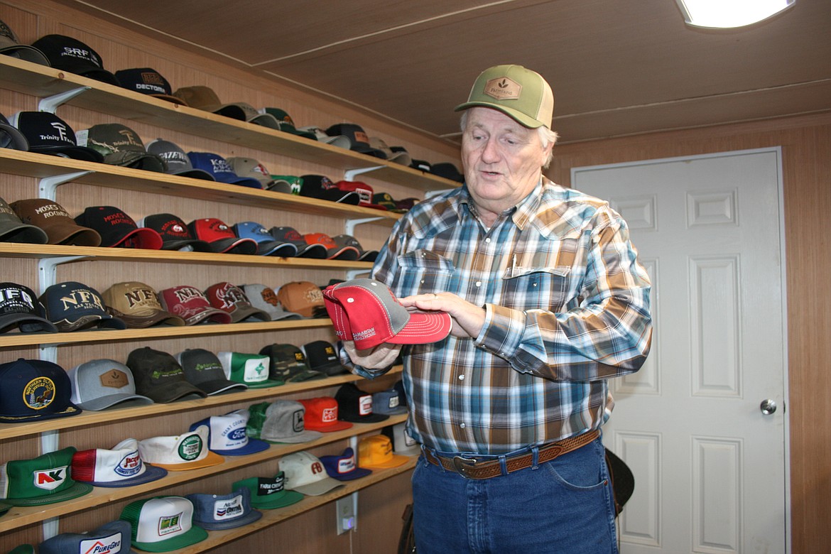 Mike Cobb, of Moses Lake, talks about the design of a Moses Lake Roundup hat while showing his hat collection on Friday.