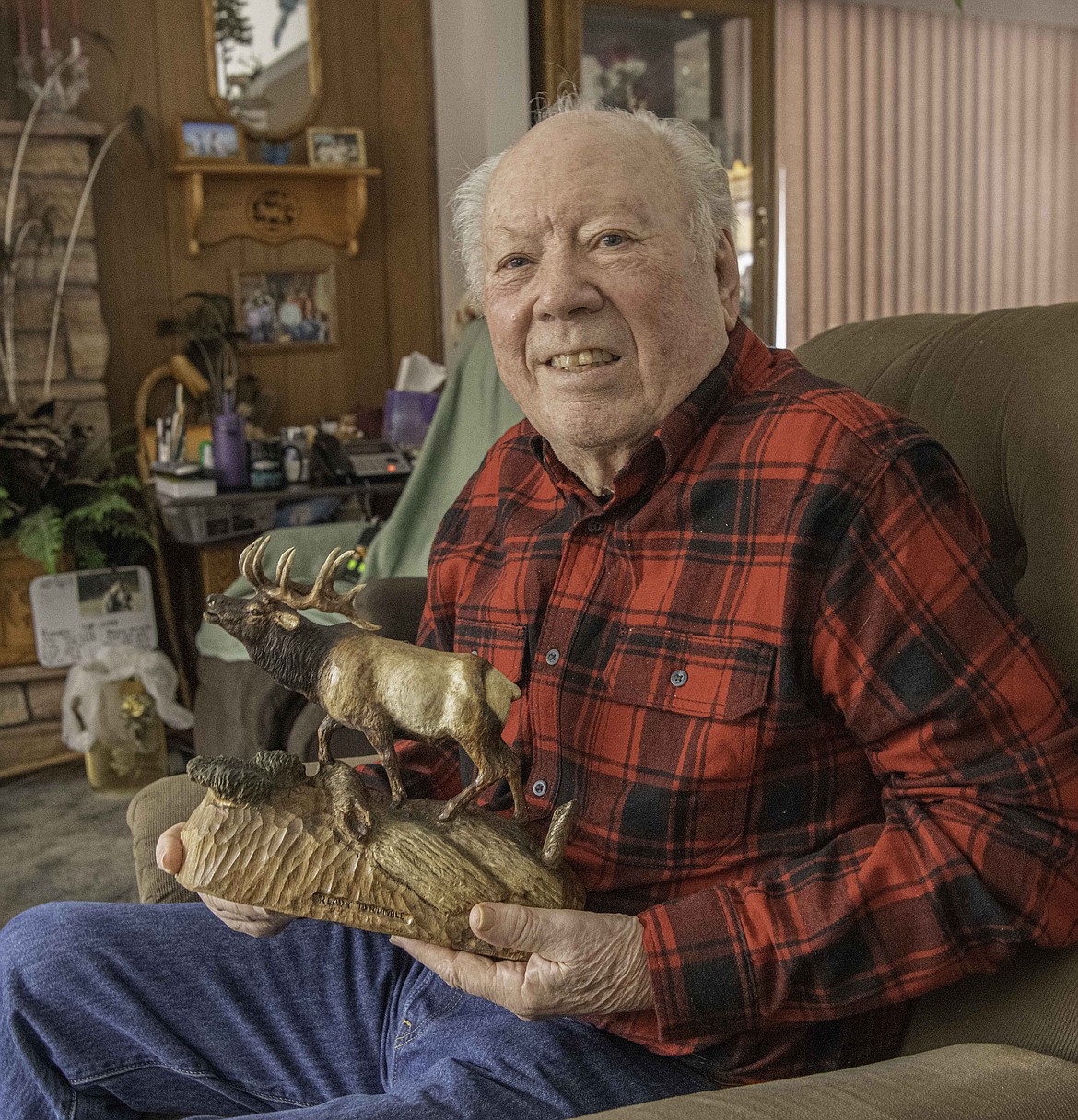 Henry Larum holds one of his carvings at his home in Plains. (Tracy Scot/Valley Press)