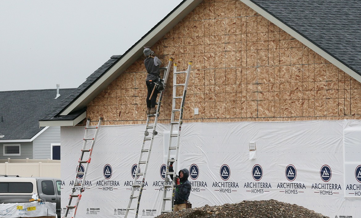 Workers build a house Monday in a new neighborhood off of Fennecus Lane in Post Falls. The Regional Housing and Growth Issues Partnership will give several presentations about the state of Kootenai County's housing crisis in the coming months.