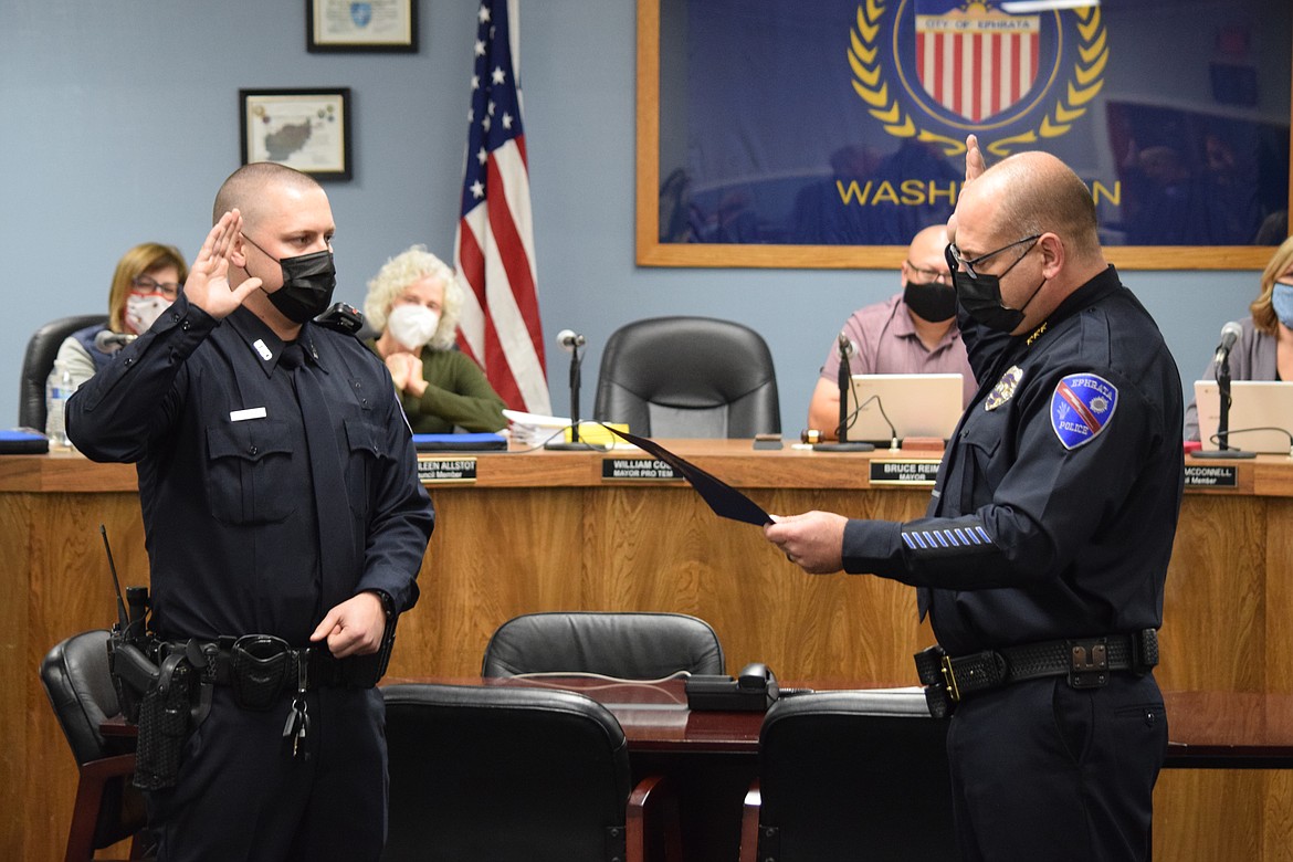 Ephrata Police Department Chief Kurt Adkins, right, swears in new EPD Officer Chandler Gribble, 26, at a meeting of the Ephrata City Council on Wednesday. Gribble, a native of Ephrata whose wife Aja works as a Grant County Sheriff’s deputy, said being a police officer in Ephrata “is everything I hoped it would be.”