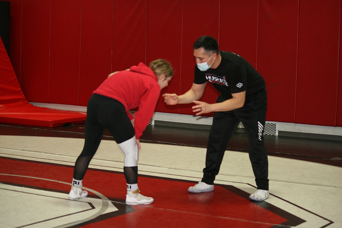 Othello High School wrestler Lexi Monday (left) works with head coach Rafael Ruiz (right) during practice Jan. 13.