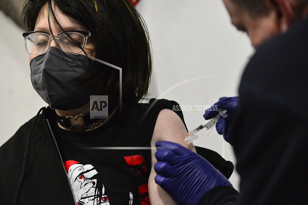 Riley Bredbeck, 13, from Westminster, Vt., looks away when getting the Pfizer COVID-19 booster during a vaccine clinic that was hosted by Rescue Inc. at Bellows Falls Fire Department, Friday, Jan. 14, 2022, in Bellows Falls, Vt. The COVID-19 booster drive in the U.S. is losing steam, worrying health experts who have pleaded with Americans to get an extra shot to shore up their protection against the highly contagious omicron variant. (Kristopher Radder/The Brattleboro Reformer via AP)