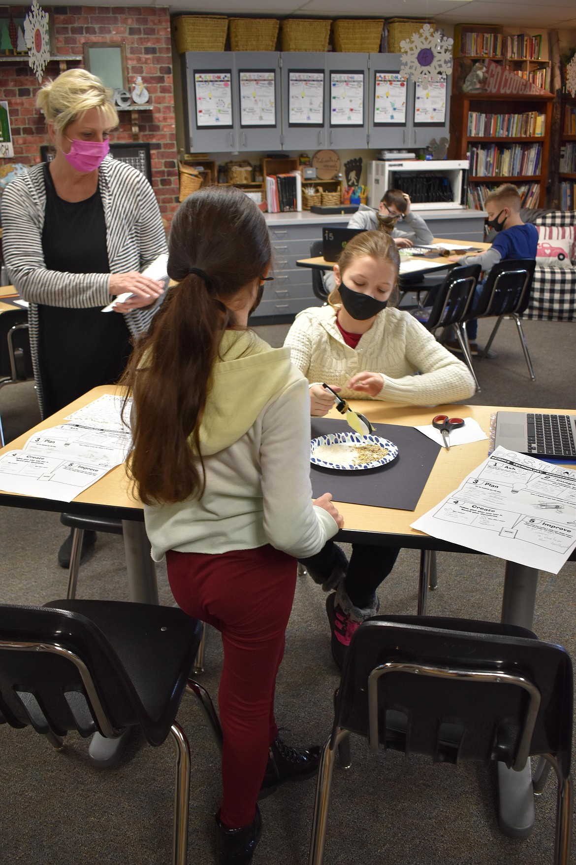 NOVA Program teacher Cathy Lane, left, leads Moses Lake students in a problem-solving activity.