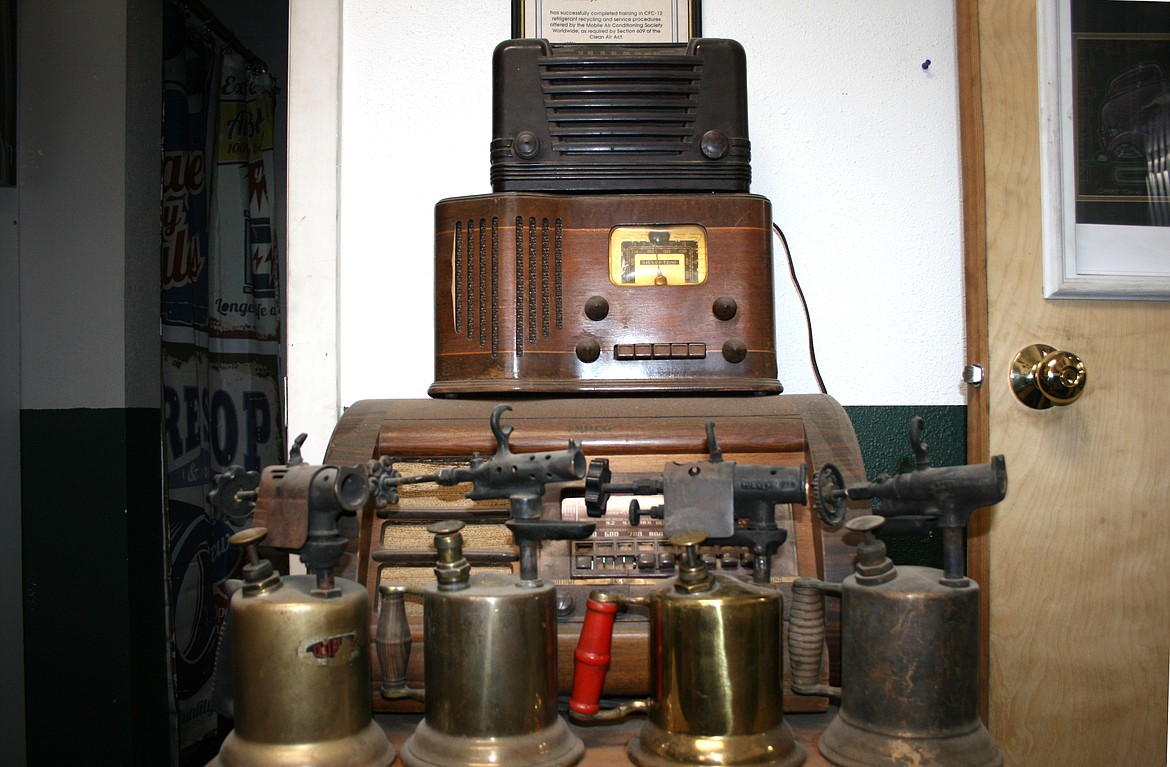 A display of vintage radios and torches on a table at Shade Tree Customs in Moses Lake on Tuesday.