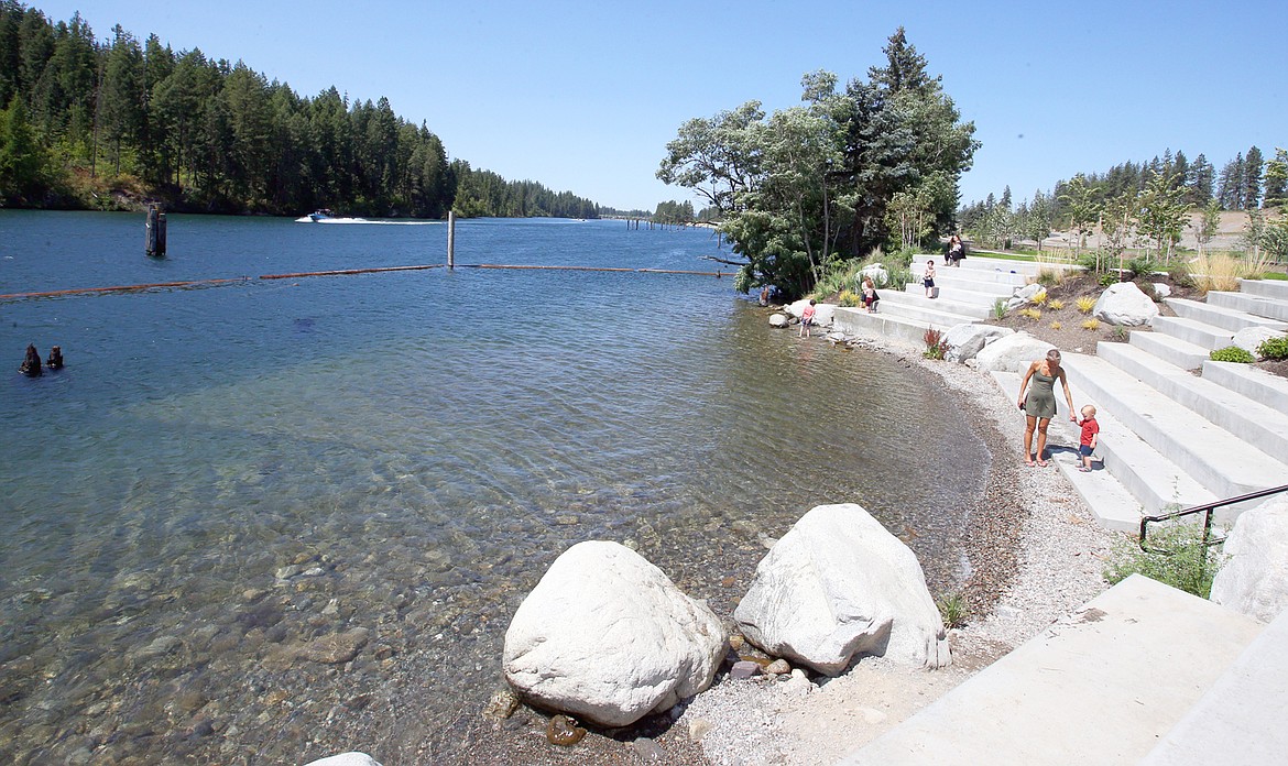 A log boom protects an area for recreational use at Atlas Waterfront Park on the Spokane River as a boat passes by last summer.