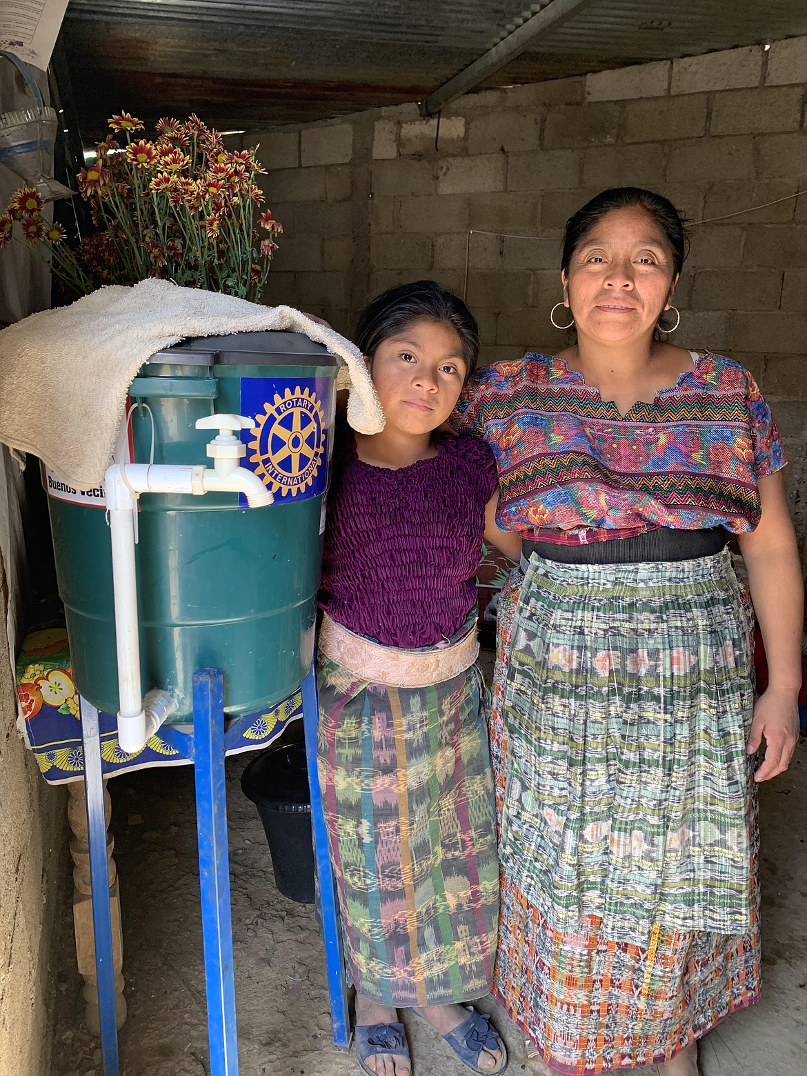 A mother and daughter stand next to a Tippy-Tap water station in the town of Montellano, where a recent inspection revealed that families' homemade water filters were working as intended and the water was running as 99% pure. (Photo provided)