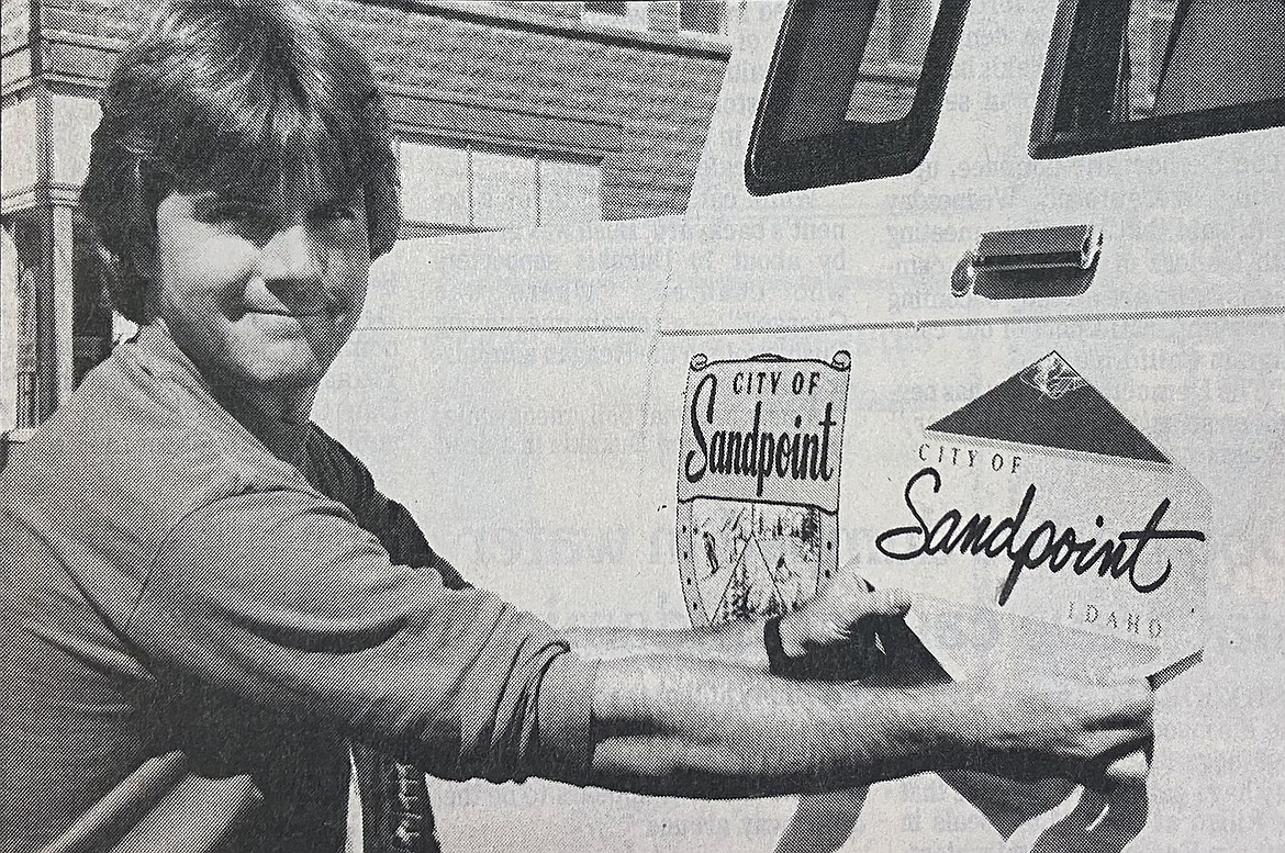 In this September 1988 photograph, then-Recreation Director Kim Woodruff is pictured replacing the old city logo on a city vehicle with a new-look city logo, pictured on the right.