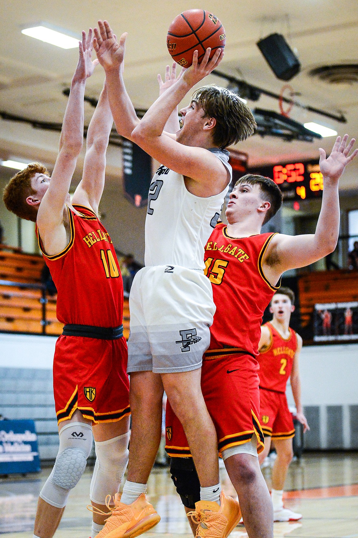 Flathead's Luca Zoeller (32) looks to shoot between Missoula Hellgate defenders Connor Dick (10) and Tommy Nilson (15) at Flathead High School on Saturday, Jan. 29. (Casey Kreider/Daily Inter Lake)