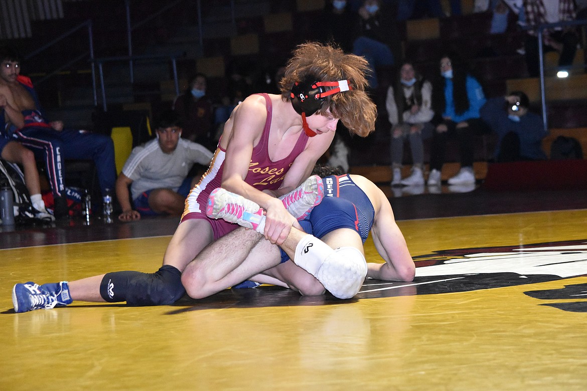 Sophomore Dayton Regan, of Moses Lake High School, has his opponent’s legs pinned as he works to win the match on Thursday.