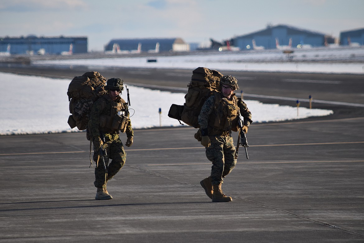 Marines with Charlie Company, 1st Battalion, 4th Regiment based at Camp Pendleton, make their way across the tarmac at the Grant County International Airport on Monday as they deploy for the Winter Fury 22 military exercise in Moses Lake.