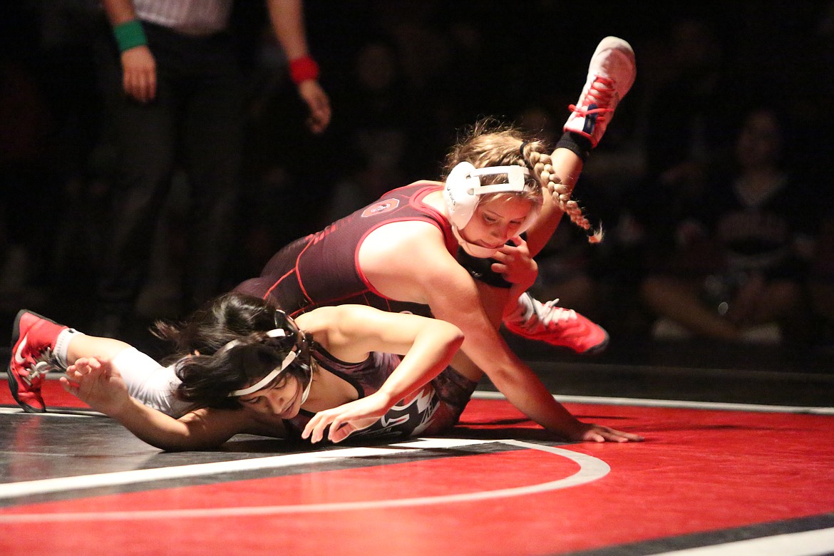 Othello High School wrestler Lexi Monday, top, takes down her opponent Elizabet Garcia, of East Valley High School, in a match Thursday at Othello.