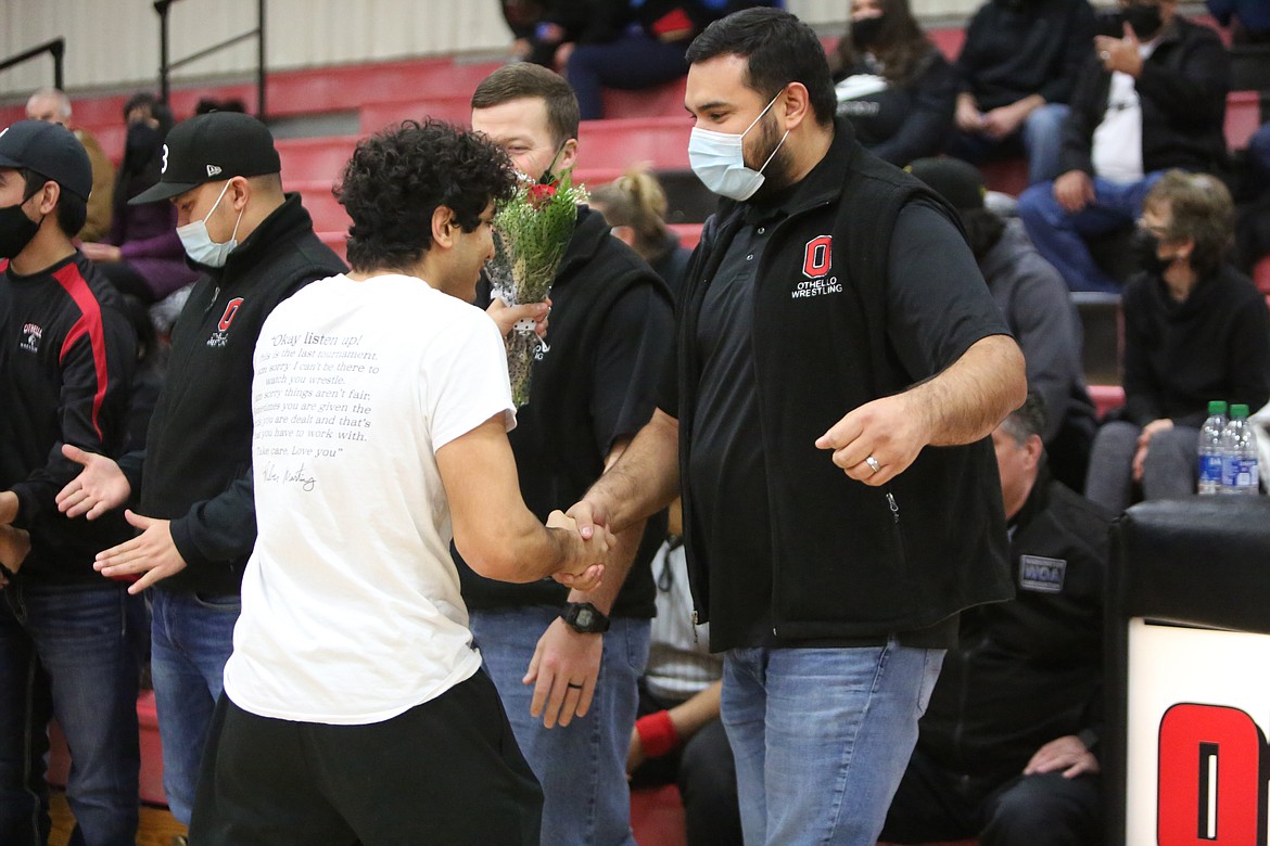 Ethan Medina, left, shakes hands with Othello High School head wrestling coach Rudy Ochoa II on Senior Night Jan. 27.