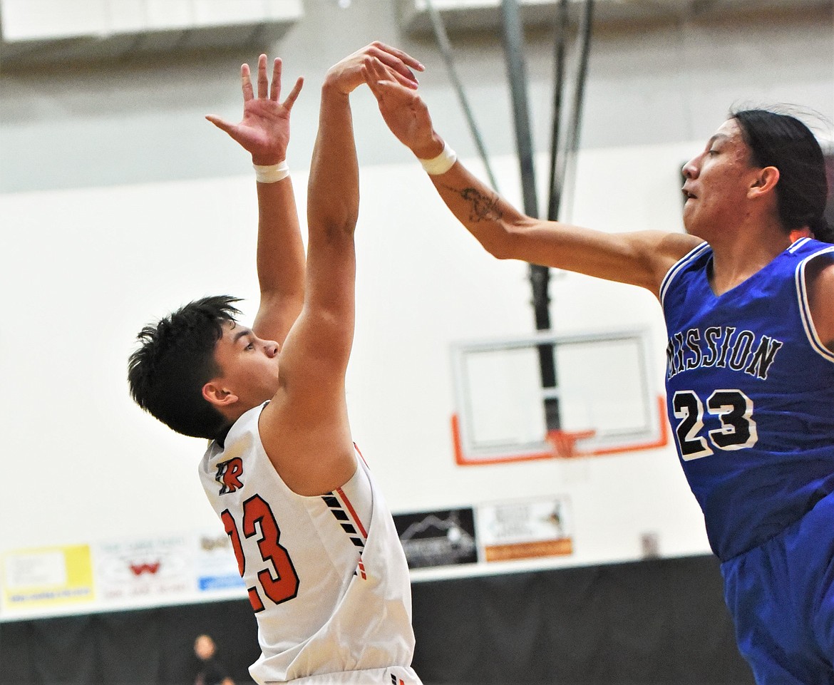 Ronan's Elijah Tonasket shoots over the defense of Cedrick McDonald. (Scot Heisel/Lake County Leader)