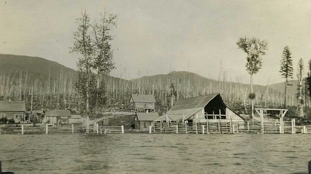 1920s picture showing the ban, outbuildings, and main rangers house far center at the Swan Lake ranger station at the south end of the lake. Given the flooding it must be late spring. (Forest Service Northern Region Archives)