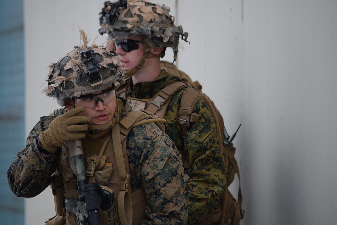 Marine Corps Lance Cpl. Ezekiel Parades (front) and Cpl. Will Skiles peer around a building as they prepare to advance on a Port of Moses Lake warehouse as part of a training exercise on Wednesday.