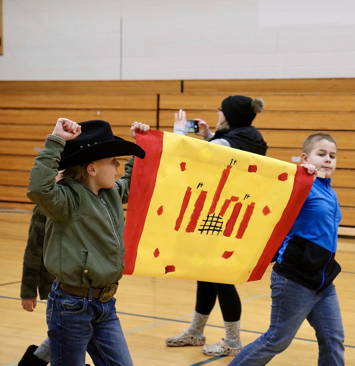 From left, fourth graders Tristan Tullis and Parker Clement represent Spain in Fernan STEM Academy's parade to celebrate the opening of the 2022 Winter Olympics in Beijing on Friday. HANNAH NEFF/Press