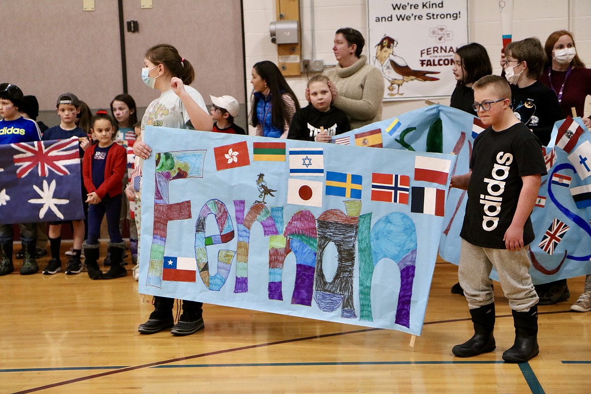 On right, third grader Brody Morgan holds up the school sign for the third through fifth grade parade at Fernan STEM Academy to celebrate the opening of the 2022 Winter Olympics in Beijing on Friday. HANNAH NEFF/Press