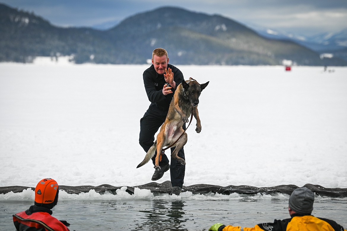 Kalispell Police Officer Jason Parce tosses K-9 Cairo into Whitefish Lake after Cairo had second thoughts about chasing his water toy during the Penguin Plunge on Saturday, Feb. 5. (Casey Kreider/Daily Inter Lake)