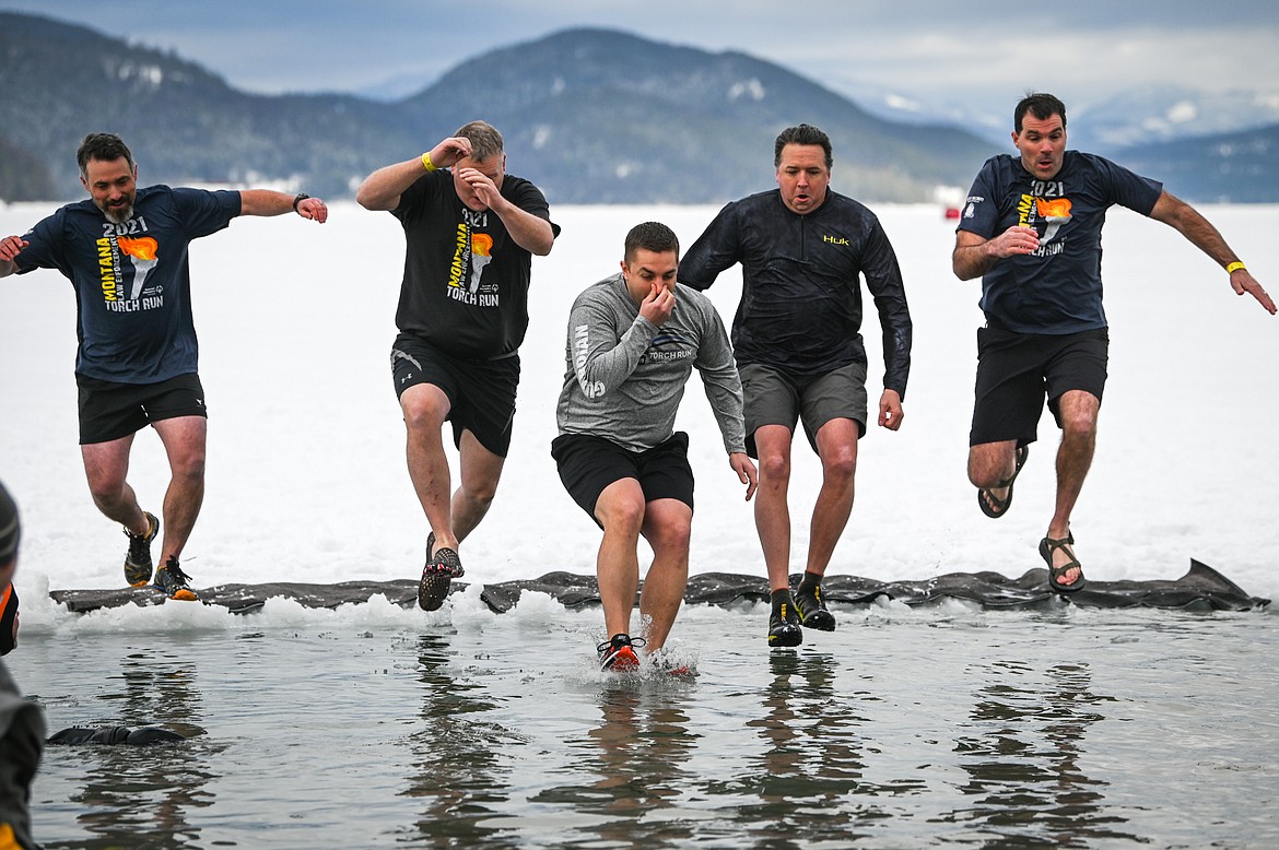 Participants leap into Whitefish Lake during the Penguin Plunge on Saturday, Feb. 5. Organized by the Law Enforcement Torch Run, as part of the Whitefish Winter Carnival, the event raised over $60,000 for Special Olympics Montana. (Casey Kreider/Daily Inter Lake)