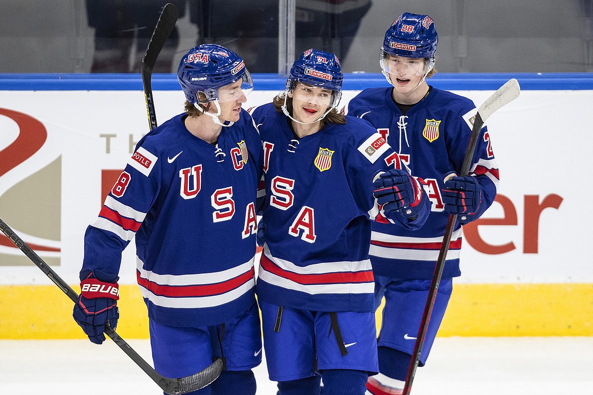 United States' Jake Sanderson, from left, Tanner Dickinson and Chaz Lucius celebrate a goal against Finland during the first period of an exhibition game in Edmonton, Alberta, Dec. 23, 2021.