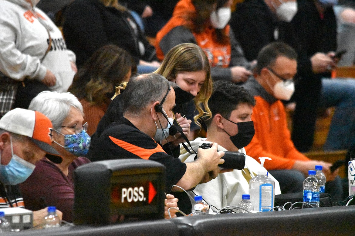 Ryan Shannon helps a student with a problem with her camera during the game between Ephrata High School (EHS) and Ellensburg High School on Jan. 21. Shannon is the announcer for EHS basketball and oversees TigerVision.