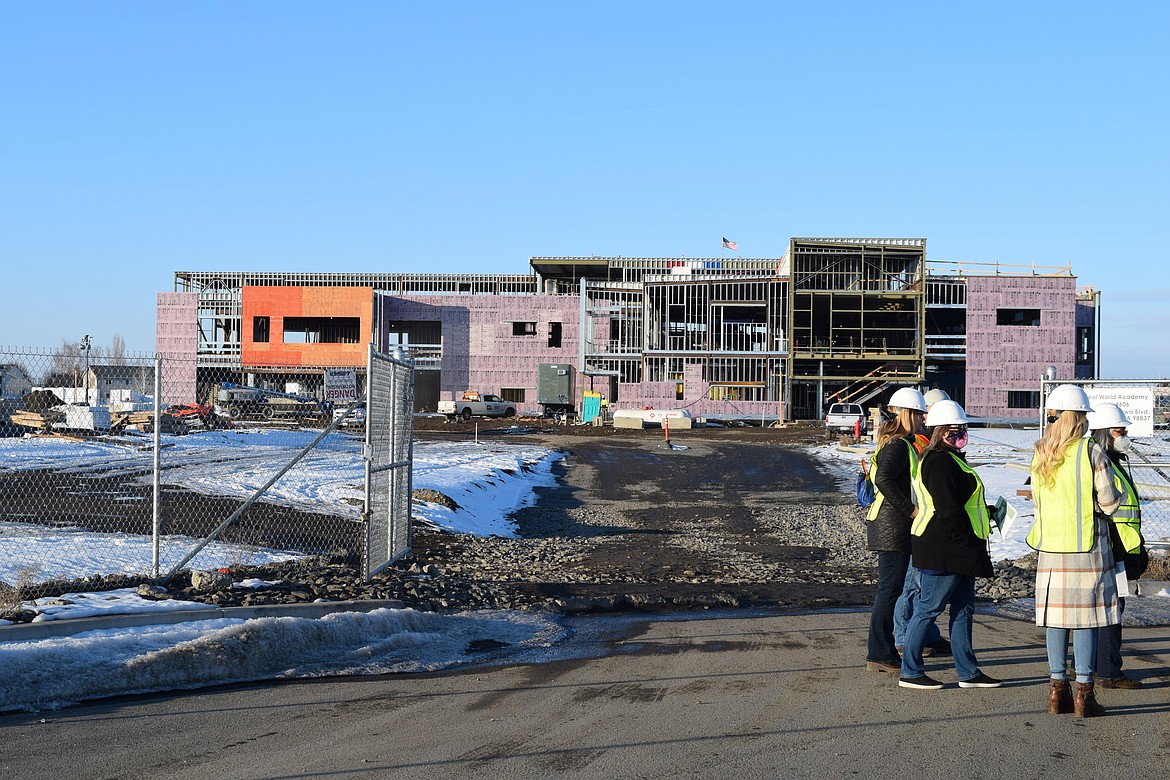 Staff members wait just outside of the construction site of Moses Lake School District’s newest campus, Vanguard Academy on Thursday. The new school is still being built, but exterior walls are beginning to go up.