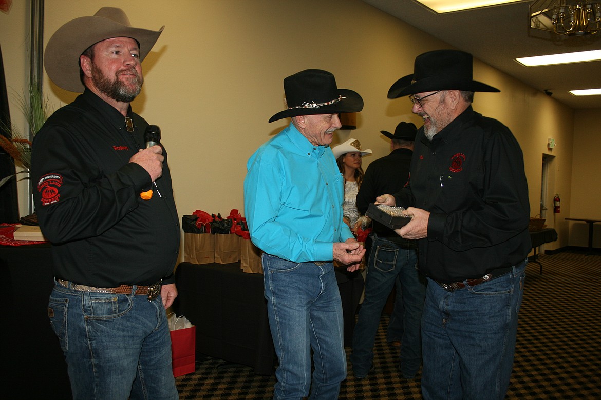 Rep. Tom Dent, R-Moses Lake, center, receives a belt buckle as Columbia Basin Rodeo Association Man of the Year from outgoing association president Rodney Rosin, left, and incoming president Stuart Platt, right, at the annual CBRA Banquet on Saturday.