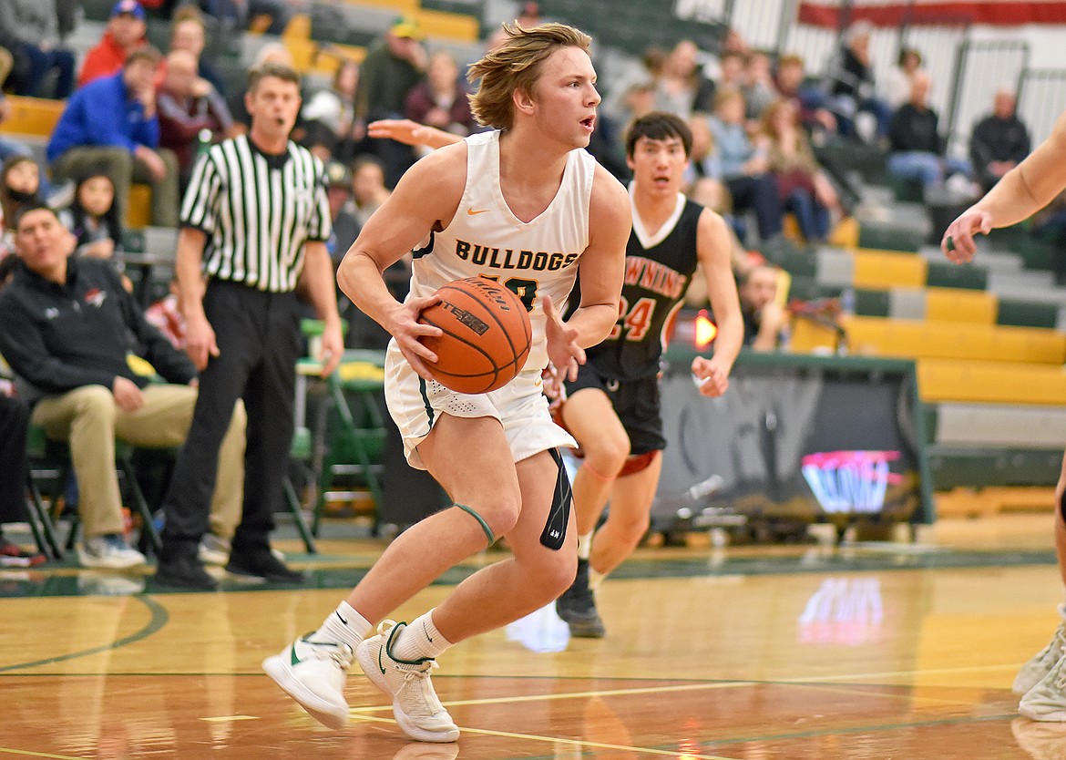 Whitefish senior Jaxsen Schlauch dribbles around the Browning defense in a game on Friday night at the high school. (Whitney England/Whitefish Pilot)