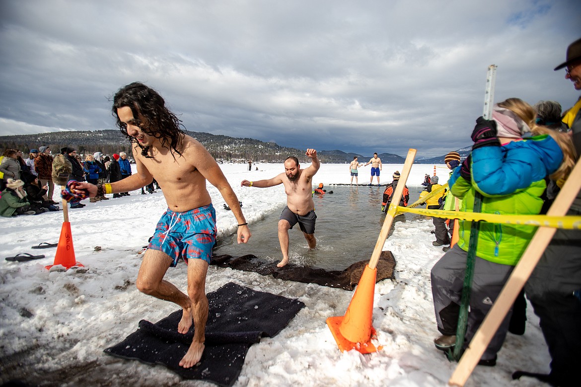 Participants in the Penguin Plunge step out of a frozen Whitefish Lake. (JP Edge photo)