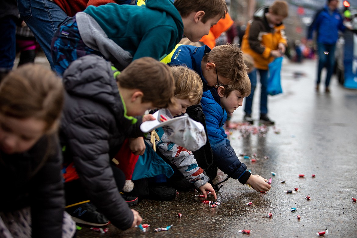 Kids pick up candy thrown in the Whitefish Carnival parade on Saturday. (JP Edge photo)