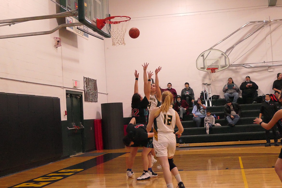 St. Regis Avery Burnham (4) scores over Two Eagle River as teammate Macy Hill readies for a possible rebound in the game Thursday night in St. Regis