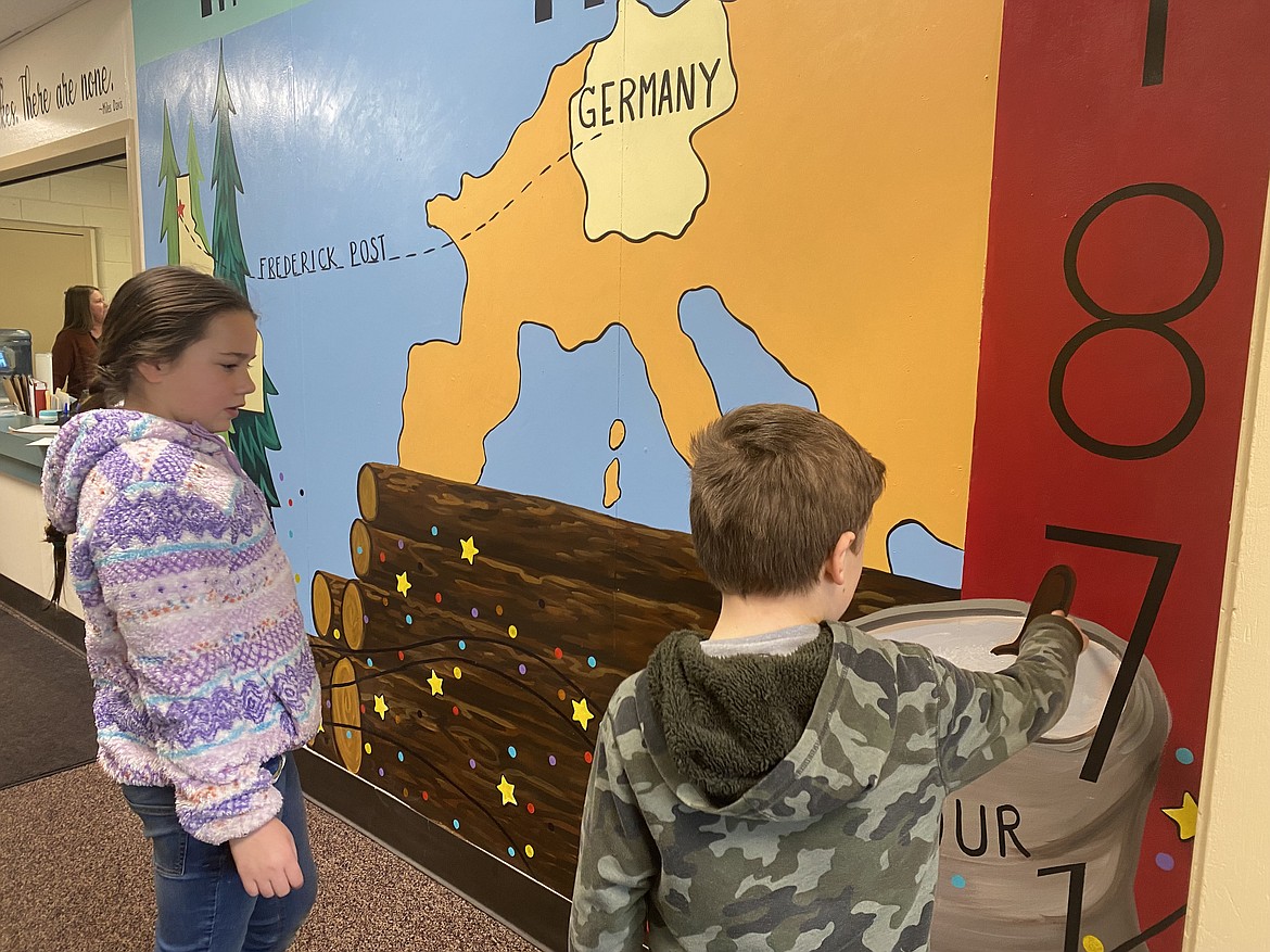Mullan Trail Elementary School students (from left,) Cambria Miller, 11, and Jared Jessop, 8, examine the hand-painted mural in the school's entryway, by local artist Christina Hull. The mural depicts key moments in the history of Post Falls.