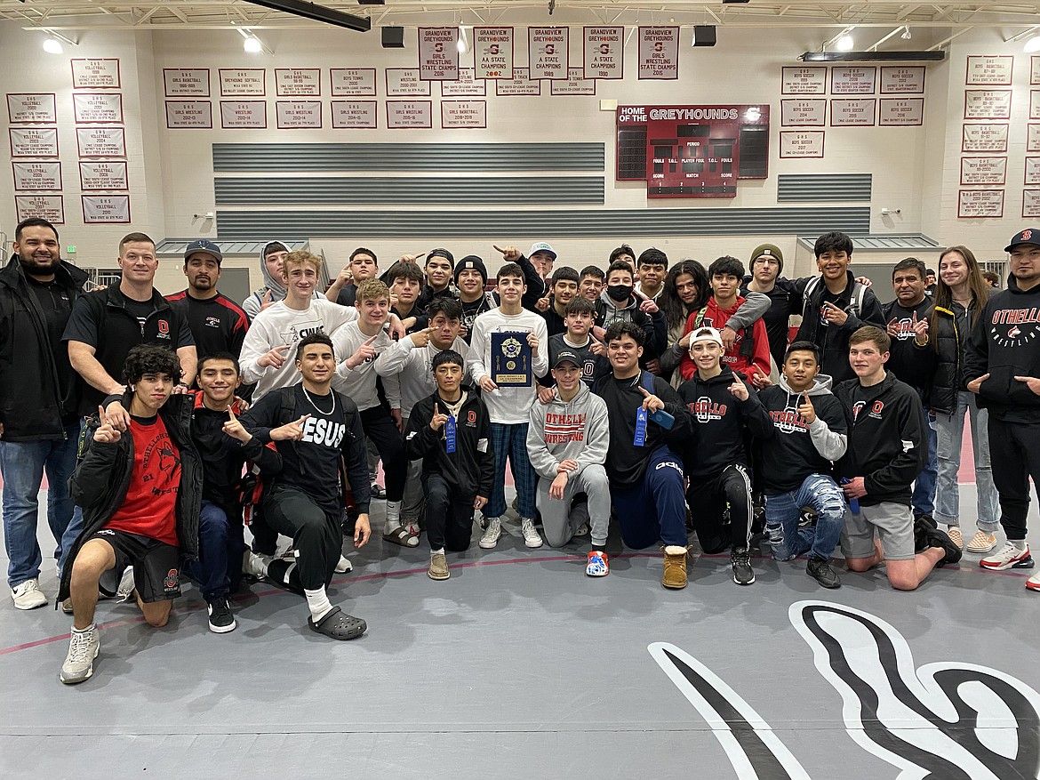 The Othello boys wrestling team shows off the Central Washington Athletic Conference first-place plaque the team won Saturday.