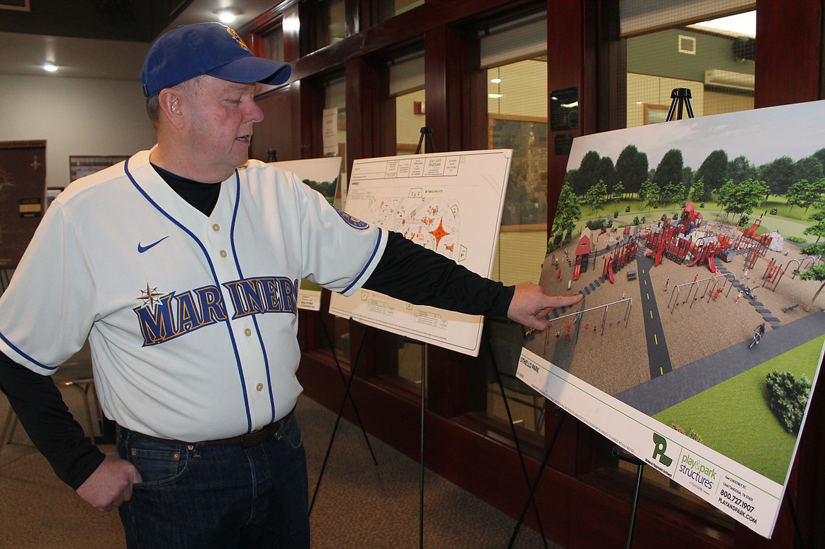 Othello Mayor Shawn Logan points out details of one of the design options for the new playground in Lions Park on Friday.