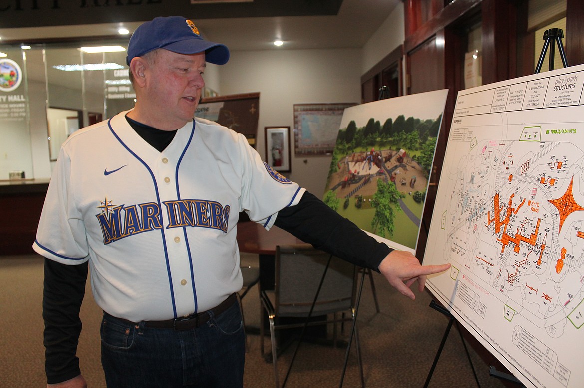 Othello Mayor Shawn Logan looks at one of the options for the design of the new Lions Park playground on Friday.