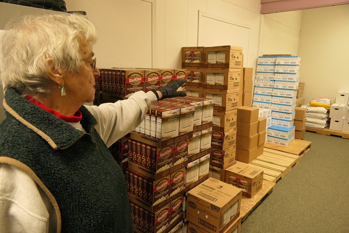 Chloe Adamson, president of the Libby Food Pantry, points to a small portion of the organization's food stores. (Derrick Perkins/The Western News)