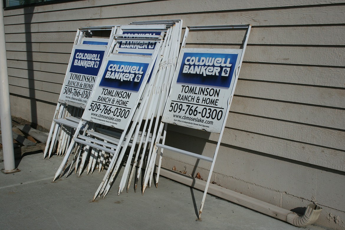 Real estate signs sit outside the Coldwell Banker Tomlinson Ranch & Home office in Moses Lake on Wednesday.