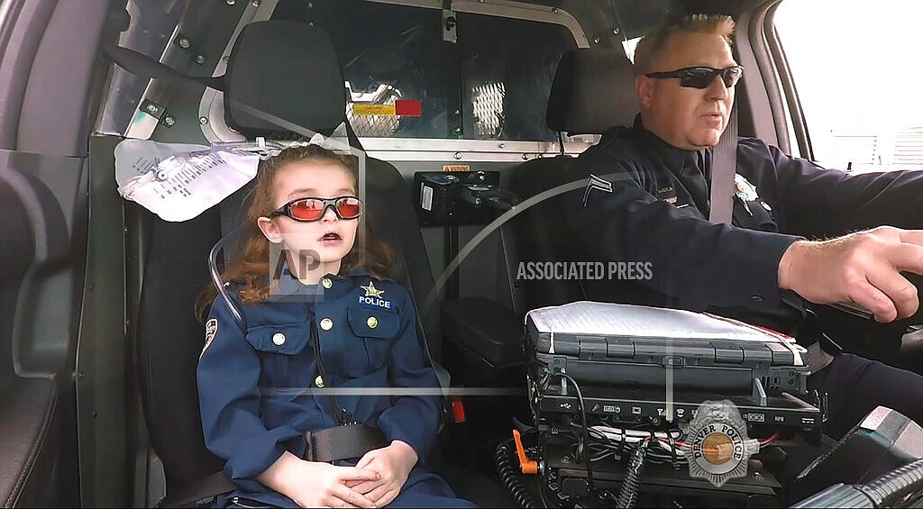 In this image from an April 2017 video provided by the Denver Police Department, Olivia Gant, who was 6 years old at the time, rides with Capt. Tim Scudder on a call in Denver. Olivia's mother, Kelly Turner, will be sentenced Wednesday, Feb. 9, 2022, after pleading guilty last month to child abuse resulting in death, charitable fraud and theft between $100,000 and $1 million, according to prosecutors. Authorities say she duped doctors about her daughter’s health, leading to unnecessary surgeries and medications. (Denver Police Department via The Denver Post via AP)
