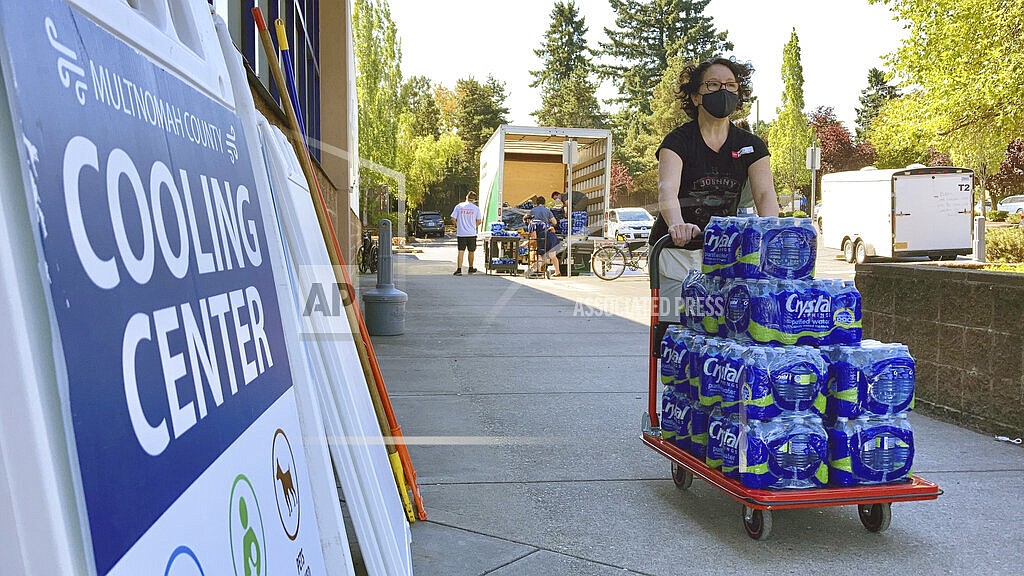 A volunteer helps set up snacks at a cooling center established to help vulnerable residents ride out a dangerous heat wave on Aug. 11, 2021. The historic heat wave, which toppled all-time temperature records, killed more than 200 people in Oregon and Washington. Now, lawmakers in the Pacific Northwest are eyeing several emergency heat relief bills aimed at helping vulnerable populations. The proposed measures would provide millions in funding for cooling systems and weather shelters during future extreme weather events. (AP Photo/Gillian Flaccus, File)