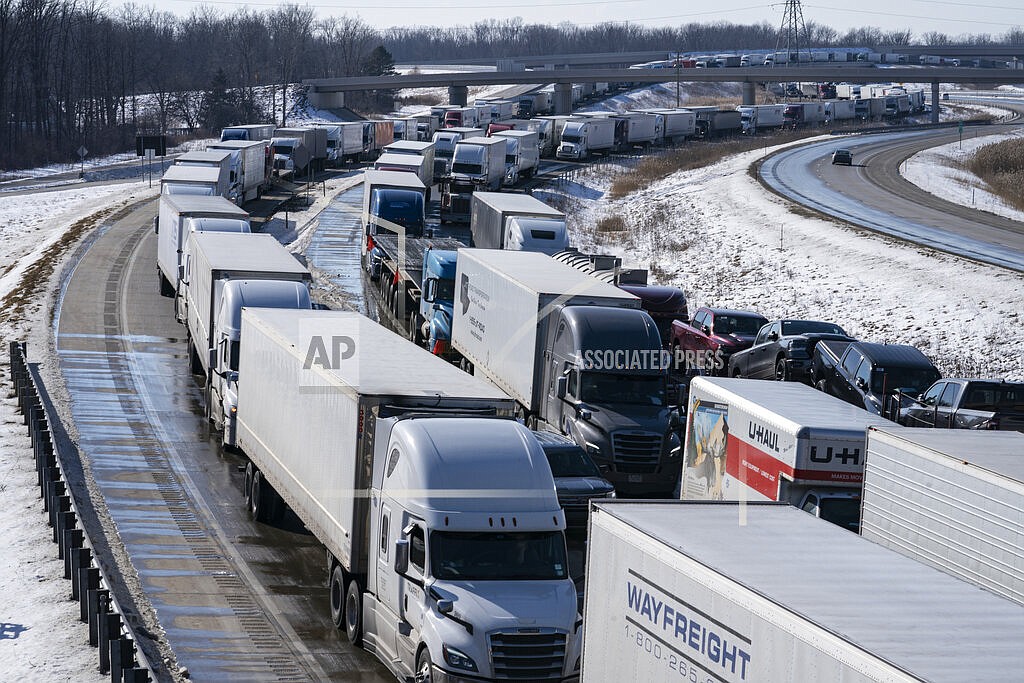 Trucks heading to Canada are stuck in heavy traffic after they were diverted to the Blue Water Bridge in Port Huron, Mich., Wednesday, Feb. 9, 2022, after the Ambassador Bridge was closed due to Canadian anti-vaccine protests. (Mandi Wright/Detroit Free Press via AP)