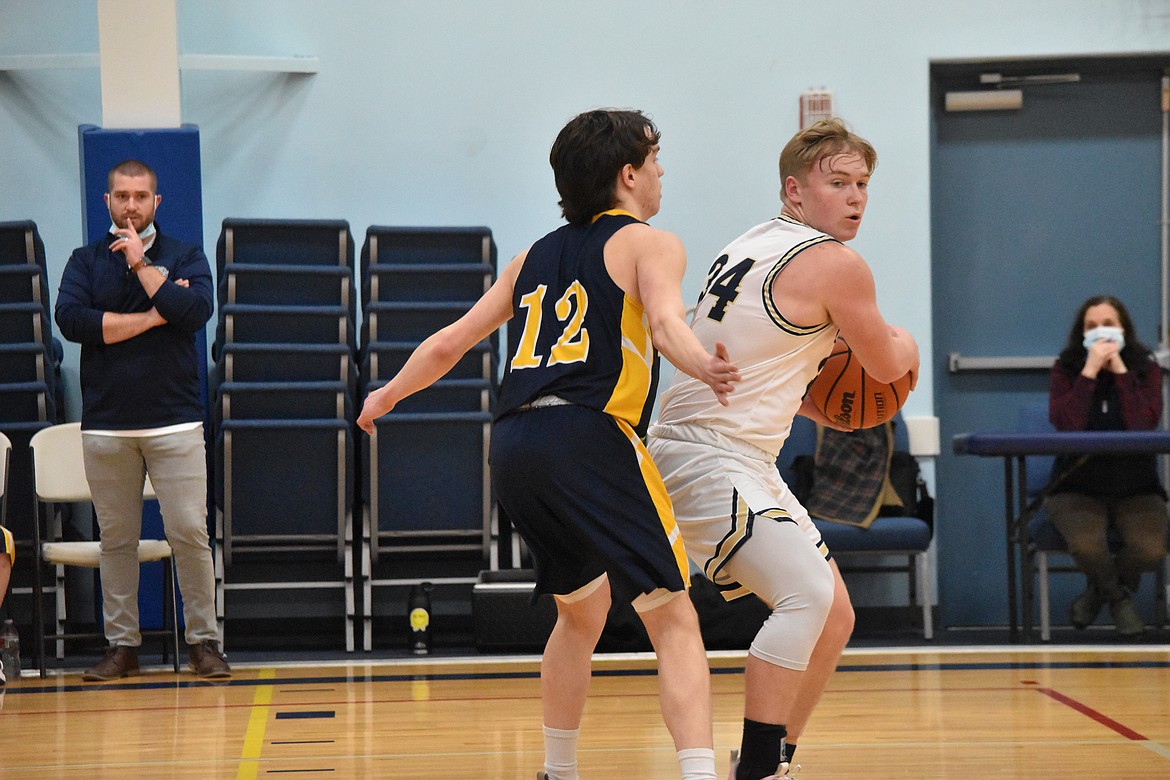 MLCA/CCS sophomore Jonah Robertson (34) tries to maneuver around Cascade Christian Academy senior Ethan Davis (12) on Wednesday.