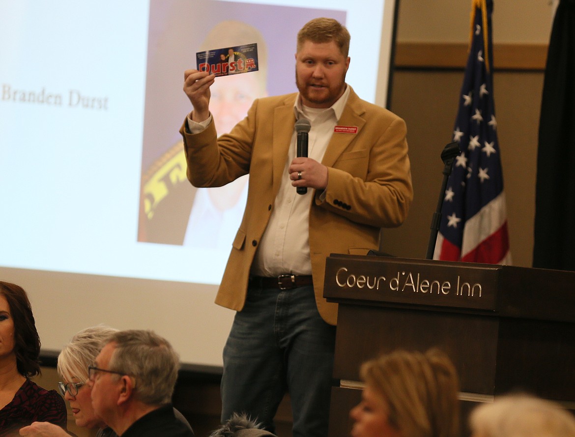 Branden Durst, a candidate for state superintendent, holds up a campaign flyer Thursday during the Kootenai County Republican Women Federated meeting.