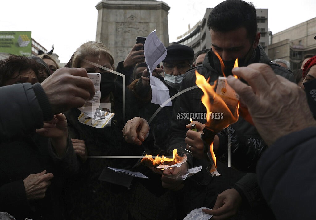 People set on fire their electricity bills during a protest in Ankara, Turkey, Wednesday, Feb. 9, 2022. Spiking energy prices are raising utility bills from Poland to the United Kingdom, leaving people struggling to make ends meet and small businesses uncertain about much longer they can stay afloat. (AP Photo/Burhan Ozbilici)