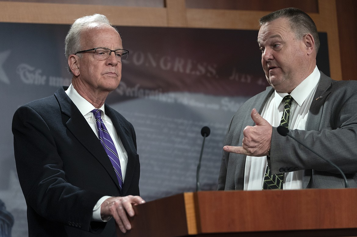 Sen. Jon Tester, D-Mont., right gestures toward Sen. Jerry Moran, R-Kan., as they speak about health care for post-9/11 toxic-exposed veterans, Tuesday, Feb., 1, 2022, on Capitol Hill in Washington. (AP Photo/Jacquelyn Martin)