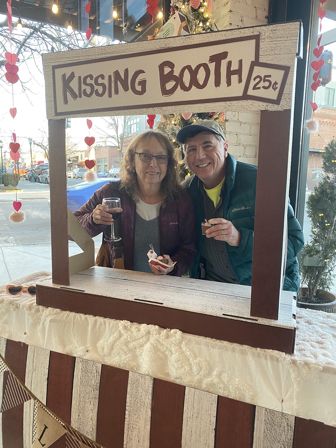 Newlyweds Jim and Kathy McFeeley stopped at the kissing booth at Woops! Bakeshop in downtown Coeur d'Alene Friday night during the Chocolate Affair event.