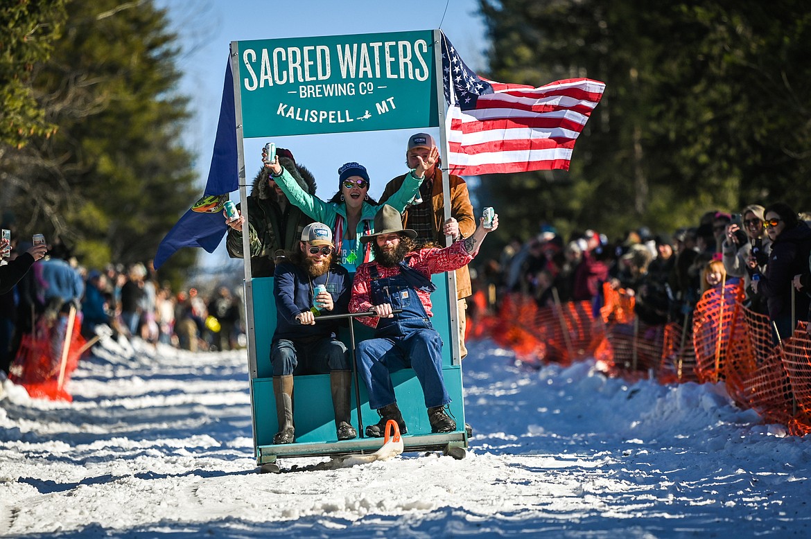 The team from Sacred Waters Brewing Company races down Sugar Hill during the Barstool Ski Races at the 43rd annual Cabin Fever Days in Martin City on Saturday, Feb. 12. (Casey Kreider/Daily Inter Lake)