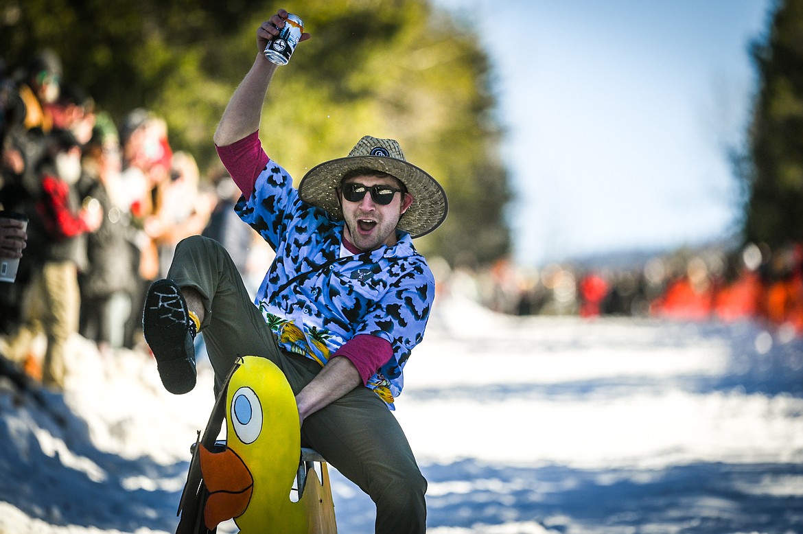 A participant hoists a beer in the air as he races down Sugar Hill during the Barstool Ski Races at the 43rd annual Cabin Fever Days in Martin City on Saturday, Feb. 12. (Casey Kreider/Daily Inter Lake)